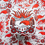 A 3.3x3.3" metallic vinyl art sticker of a hand shaking hands with the devil. The two hands a chained together. A banner above the hands reads: Down with my demons. Flames spill from above the banner. Drawn in a flash tattoo and pop art fusion style in a red, white and black color palette by the artist, Red Halftone.